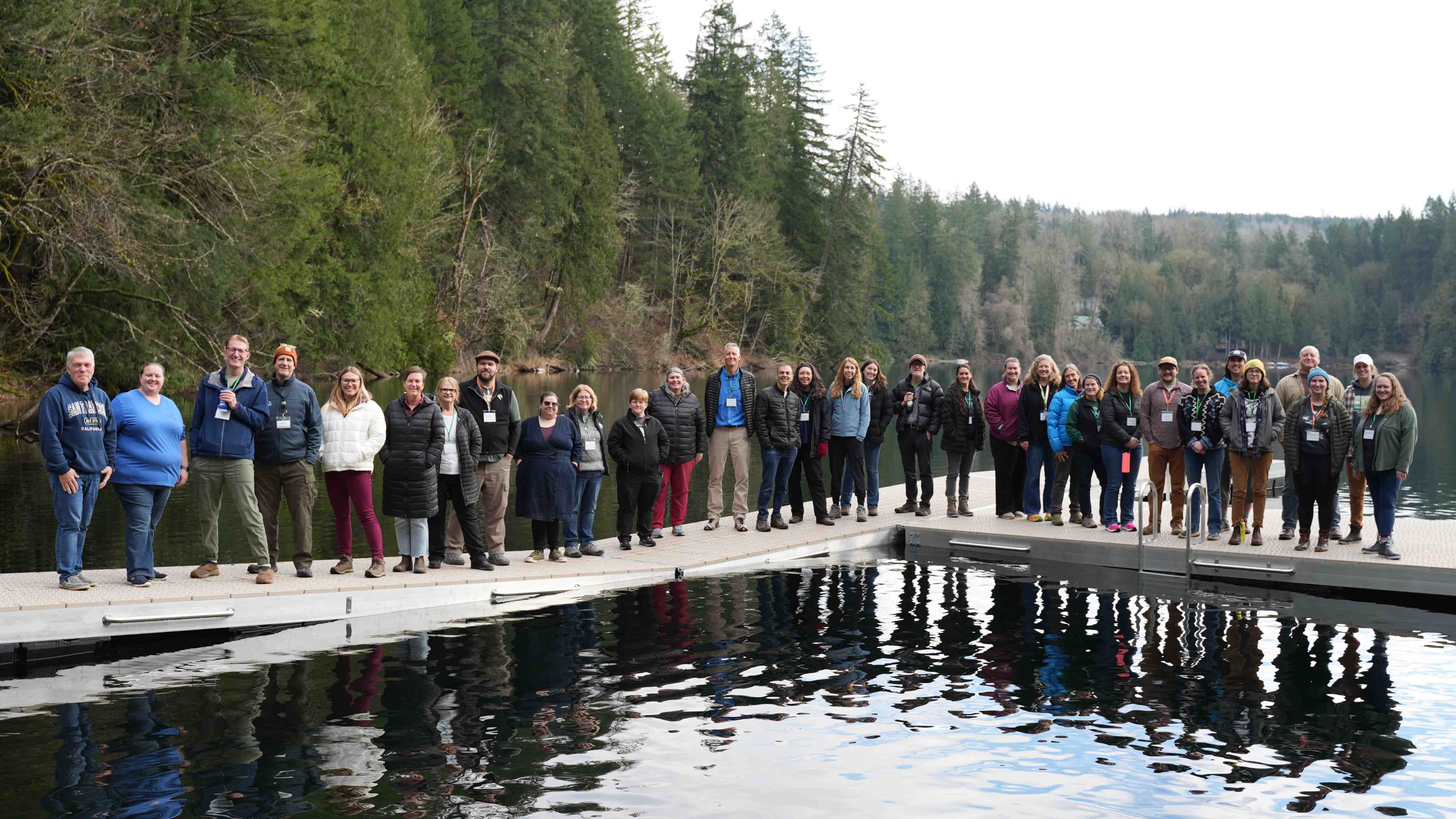 WOSLN Workshop - January 2025 A group of over 30 people stand on a floating dock in a lake cove.
