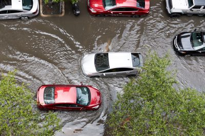 This image shows cars unable to navigate very flooded roads.