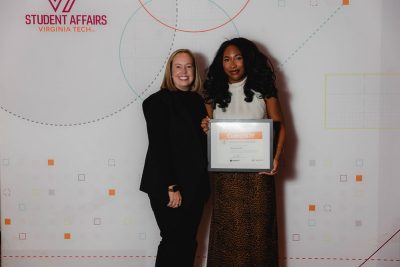 Two people holding a award certificate.